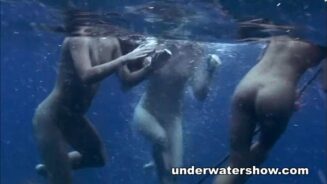 Tre ragazze che nuotano nude nel mare
